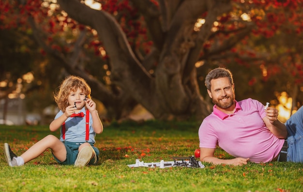 Padre juega al ajedrez con juegos de hijo y entretenimiento para niños concepto familiar