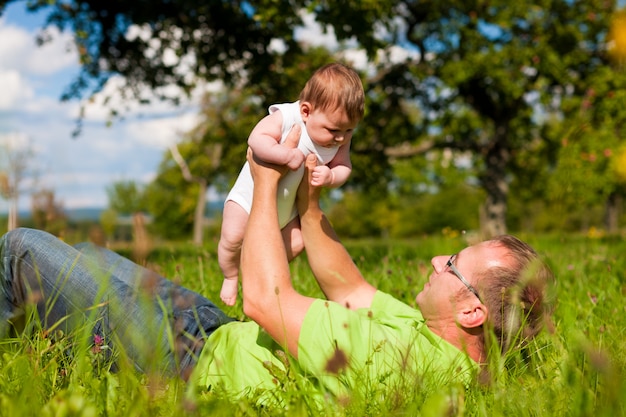 Padre jugando con el bebé en el prado