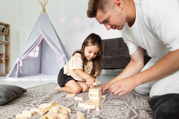 Padre jugando con su hija en casa