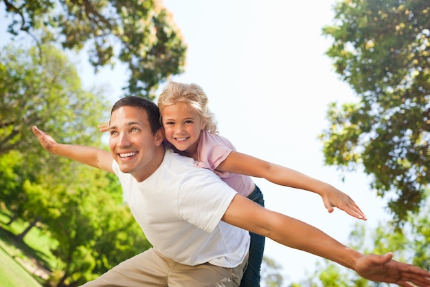 Padre jugando con su hija en el parque