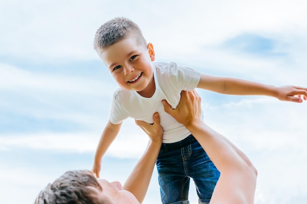 Padre lanzando a su pequeño hijo en el aire tiempo en familia juntos feliz niño divirtiéndose con h