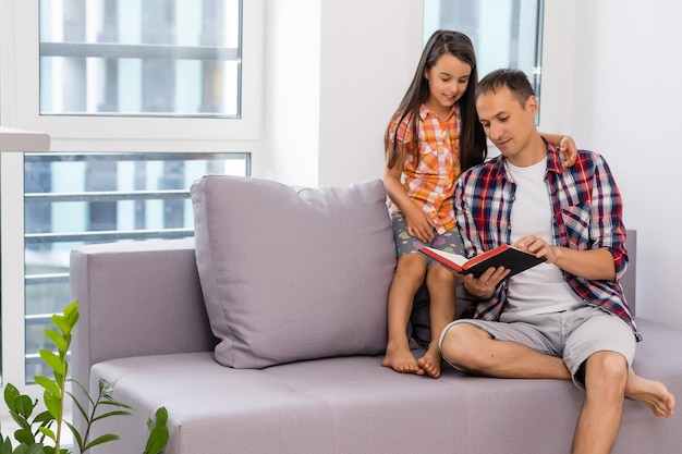 Foto padre leyendo la biblia a su pequeña hija en casa