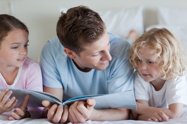 Padre leyendo con sus hijos