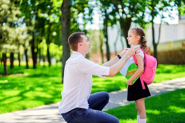 Padre lleva a la hija a la escuela en primer grado