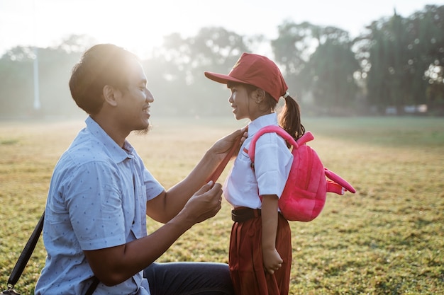 Padre llevando a su hija a la escuela primaria por la mañana