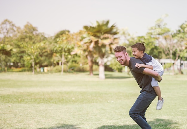 Foto padre llevando a su hijo en el campo