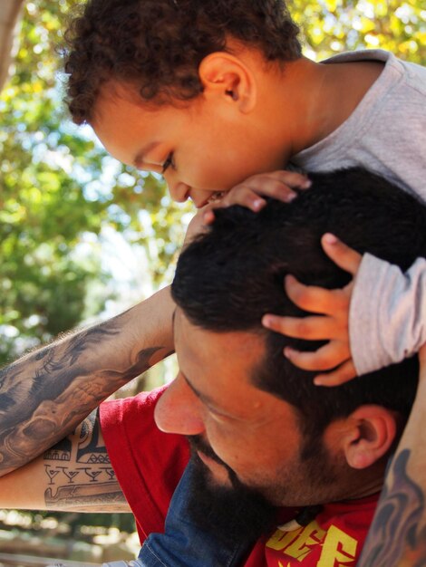 Foto padre llevando a su hijo en el hombro