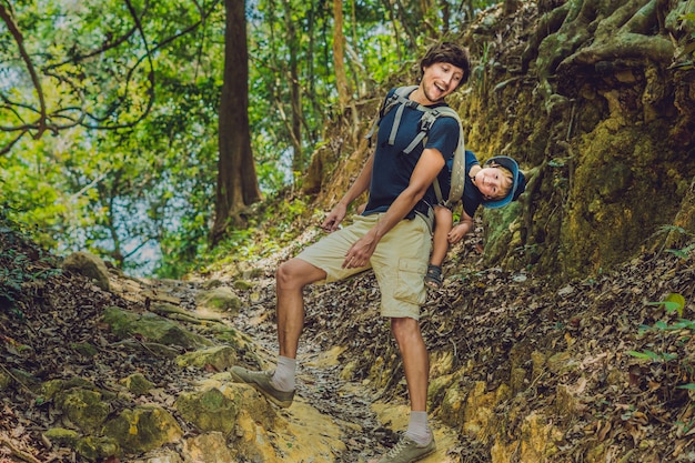 Padre llevando a su hijo sobre su espalda en la naturaleza