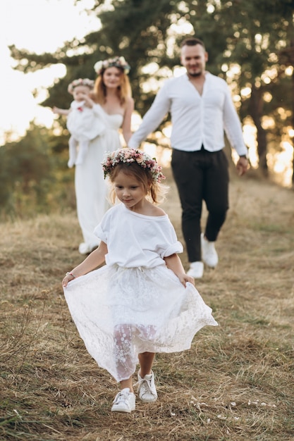 Padre, madre y dos hijas pasando tiempo y jugando en la naturaleza.