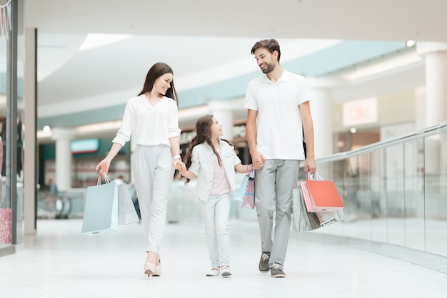 Padre, madre e hija están caminando a otra tienda.