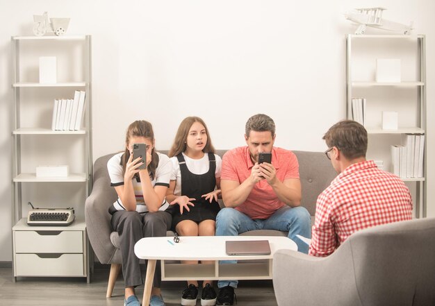 Padre, madre e hijo adictos al teléfono en terapia de psicólogo familiar