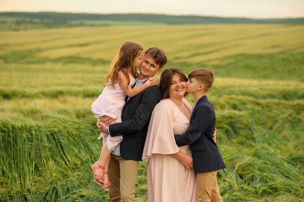 Padre madre e hijo e hija en un campo de trigo