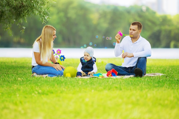 Padre, madre e hijo en un picnic en el parque.