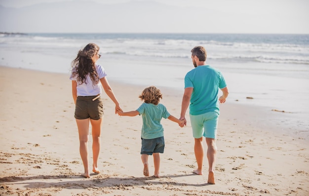 Padre, madre e hijo en la playa de verano al atardecer, concepto de vacaciones de verano en familia