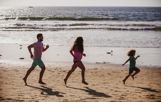 Padre, madre e hijo trotando en la playa, concepto de estilo de vida familiar saludable, gente de verano, vacaciones