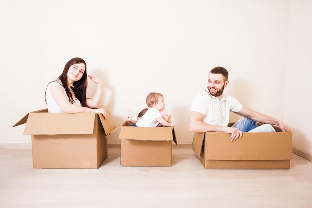 Padre, madre e hijos divirtiéndose juntos. Día de la mudanza y concepto de entrega urgente