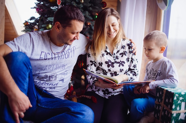 El padre, la madre y el hijo leyendo un libro