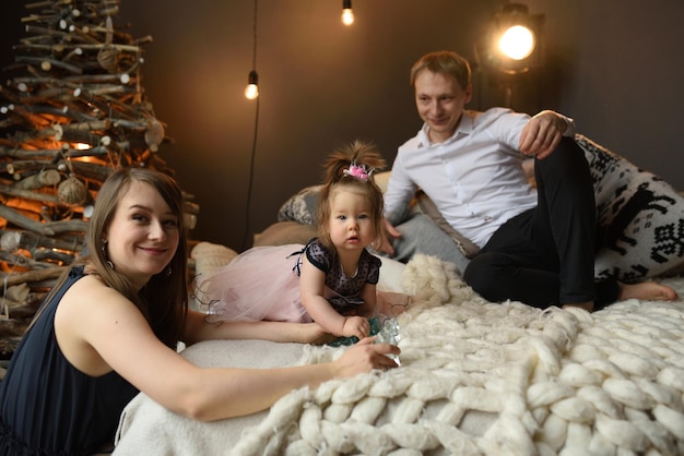 Padre mamá y su pequeña hija de un año se divierten juntos antes de navidad