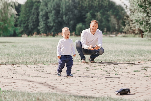 Padre mirando a su pequeño hijo mientras camina en el parque. el concepto de paternidad