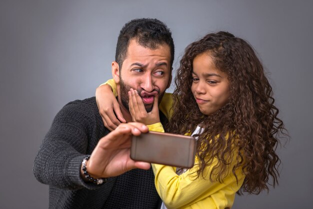 Padre negro tomando selfies con su hija