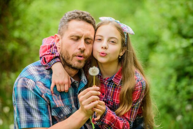 Padre niña disfruta el verano Evita que las alergias arruinen tu vida Concepto de alergias estacionales Supera las alergias Papá e hija soplando semillas de diente de león Las preguntas más importantes sobre la alergia al polen