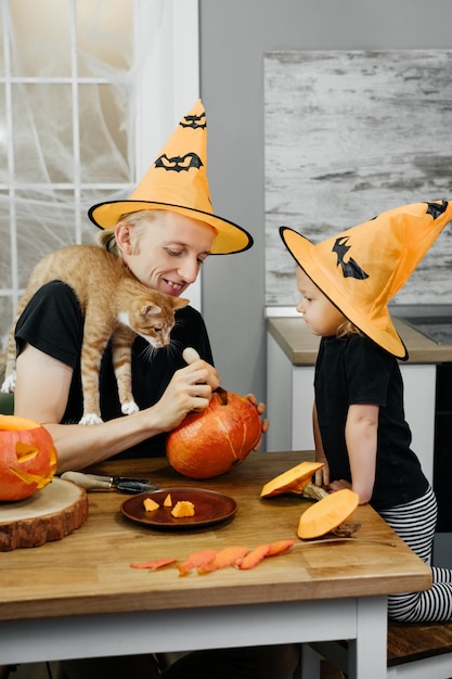 Padre con niño está tallando calabaza para halloween