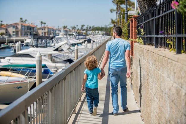 Padre con niño pequeño niño papá con niño en el día de verano crianza y paternidad vista posterior