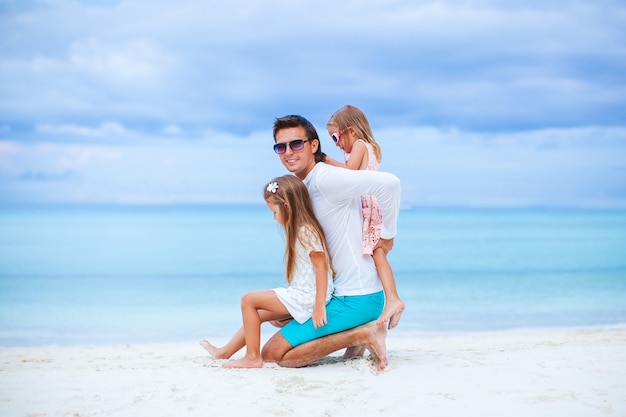 Padre con niños en la playa disfrutando del verano. Vacaciones familiares