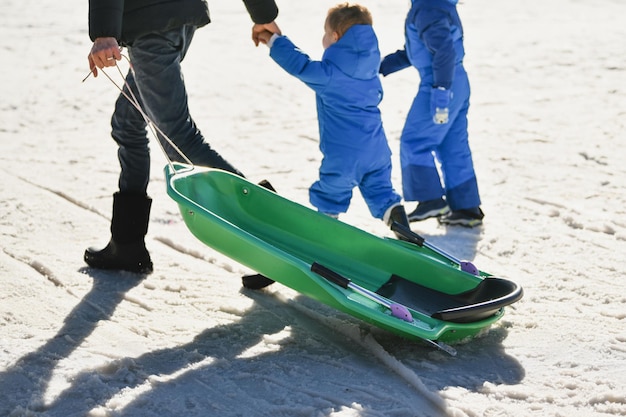 El padre con los niños en trineo en la nieve