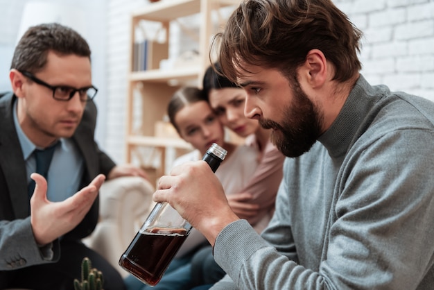 Padre en la oficina del psicólogo problemas de alcoholismo