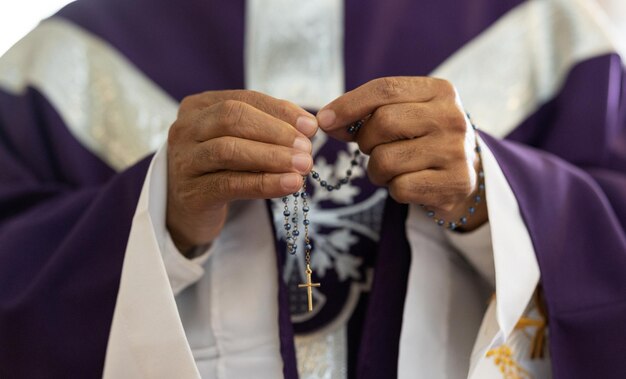 Padre pastor e homem mãos com rosário com cruz na oração da igreja e adoração católica orando ou respeito espiritual Pregador cristão fé contas com crucifixo e religião sagrada para misericórdia de Deus