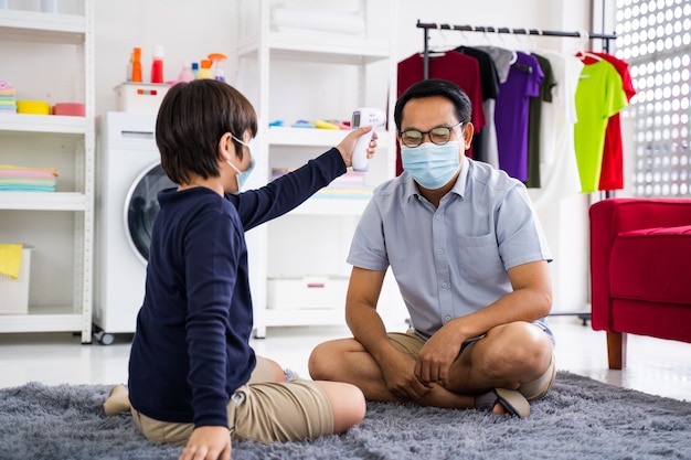 Padre se pone mascarilla médica a su hijo en cuarentena y epidemia de coronavirus en casa