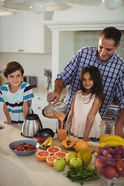 Padre prepara batido con sus hijos en la cocina