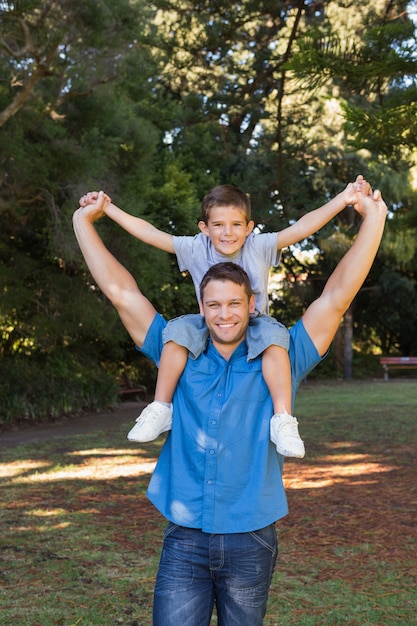 Foto padre que da a hijo alcancía y extendiendo sus brazos