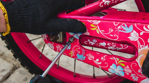 Un padre repara la bicicleta de su hija.