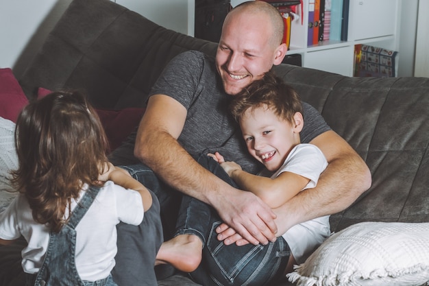 Padre ríe y juega con sus hijos