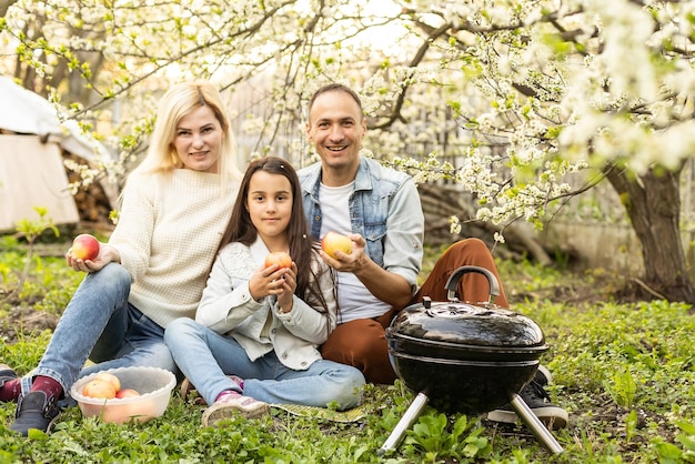 padre sonriente asando carne con su hija en el campamento.