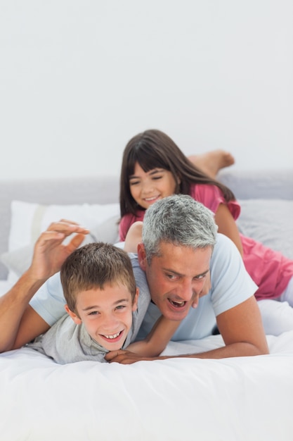 Padre sonriente divirtiéndose con sus hijos