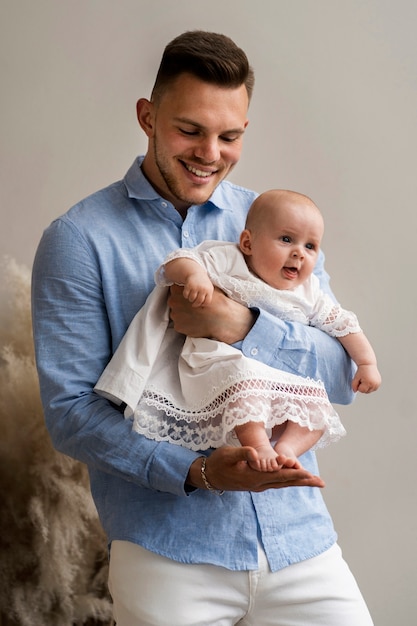 Foto padre sonriente de tiro medio con bebé