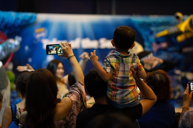 Padre sostenga a su hijo sobre su hombro para ver el espectáculo en Sea Life Bangkok Ocean World Bangkok Tailandia el 16 de abril de 2018