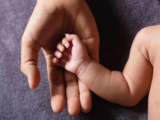 Foto padre sosteniendo la mano del bebé recién nacido en las manos