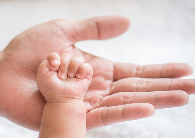 padre sosteniendo la mano del bebé