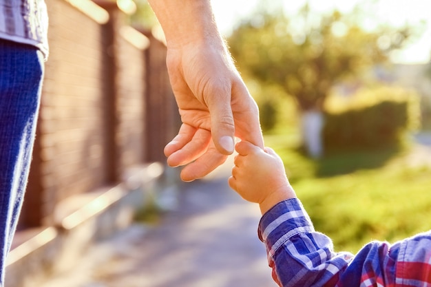 El padre sosteniendo la mano del niño con un fondo feliz