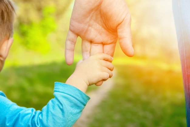 El padre sosteniendo la mano del niño