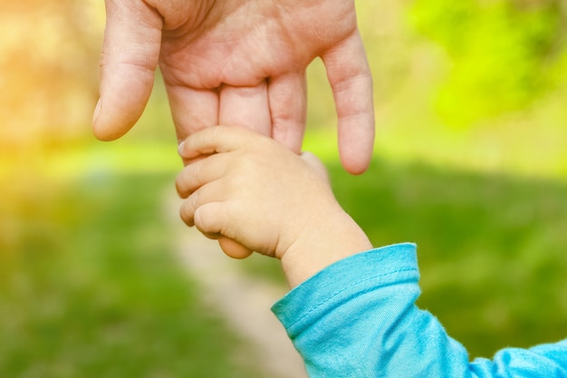 El padre sosteniendo la mano del niño