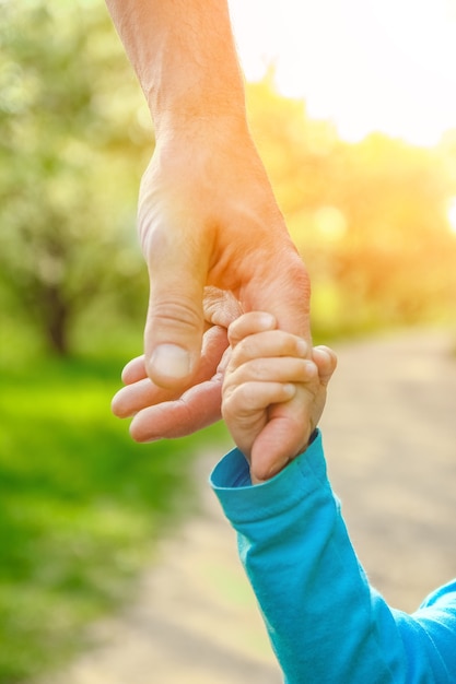 El padre sosteniendo la mano del niño