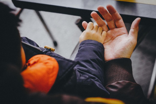 Foto padre sosteniendo la mano de su hijo en casa