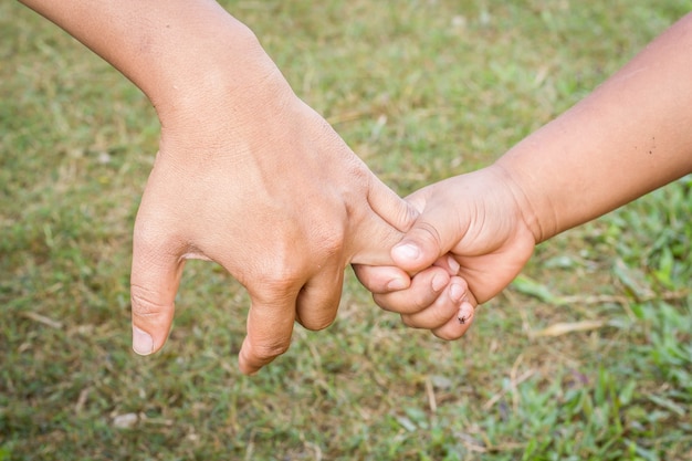 Padre sosteniendo una mano de su hijo.