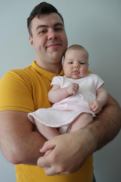 padre sosteniendo a una niña recién nacida de cuatro meses