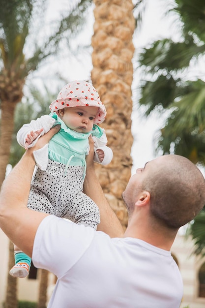 padre sosteniendo a un niño adorable en el jardín